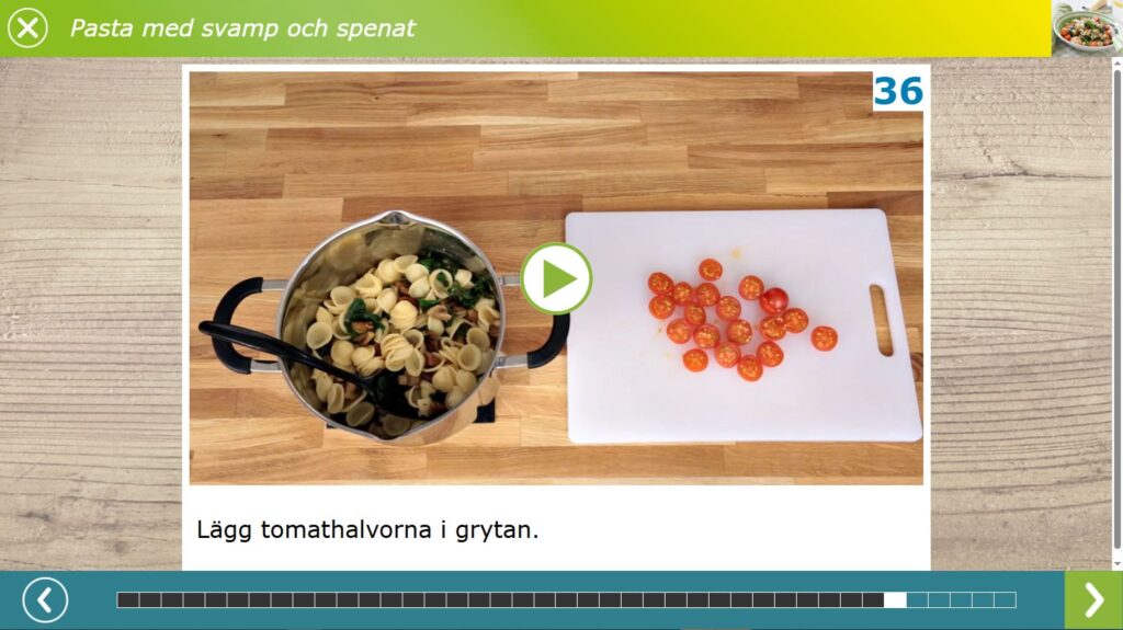 MatGlad-helt-enkelt matlagningsbild. En gryta med pasta, svamp och spenat. Bredvid ligger halvor av minitomater på en skärbräda.